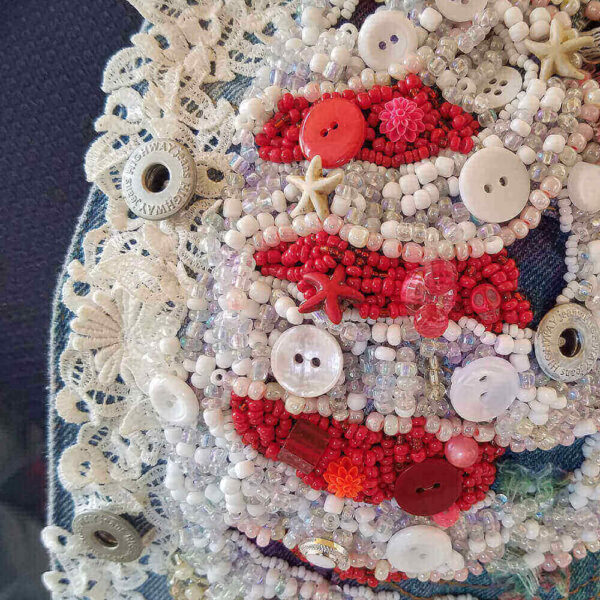 Close-up of the "Bones Jacket," highlighting the intricate detail of the white beaded ribs and the red beaded heart.