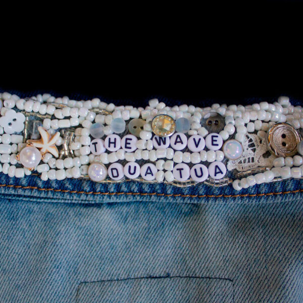 Close-up back view of the collar of one of the Pulpis denim jackets, revealing the detailed embroidery with white beads and buttons that create a textured effect