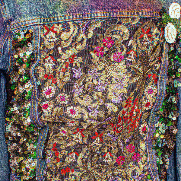 Close-up detail of the back of the Botanica Bugs jacket, showcasing the golden lace and the red and purple flowers.