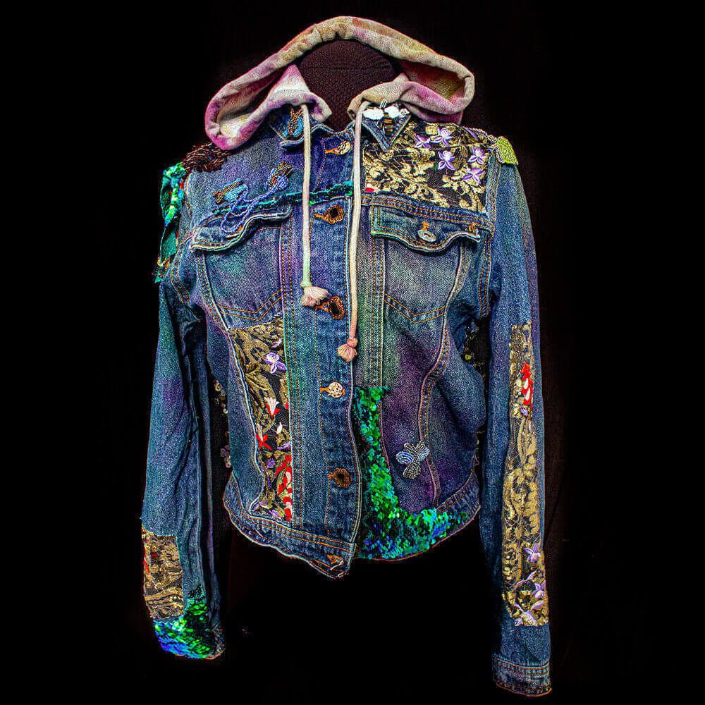 Front view of the Botanica Bugs Hooded Jacket, adorned with golden lace flowers and green sequins, and featuring insect bead patches.