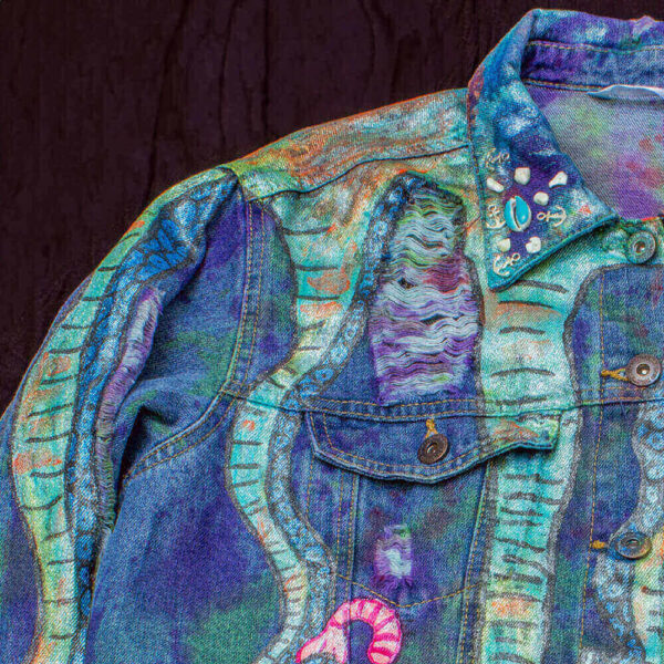 Shoulder detail of the painted tentacles on the Deep Water Jacket, showcasing a ripped effect and marine-themed beaded elements in the collar of the jacket.