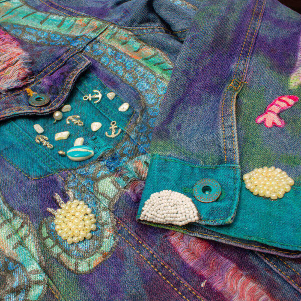 Detail of the cuff with the tie-dye texture and marine-themed beaded elements in the front of the Deep Water Jacket.