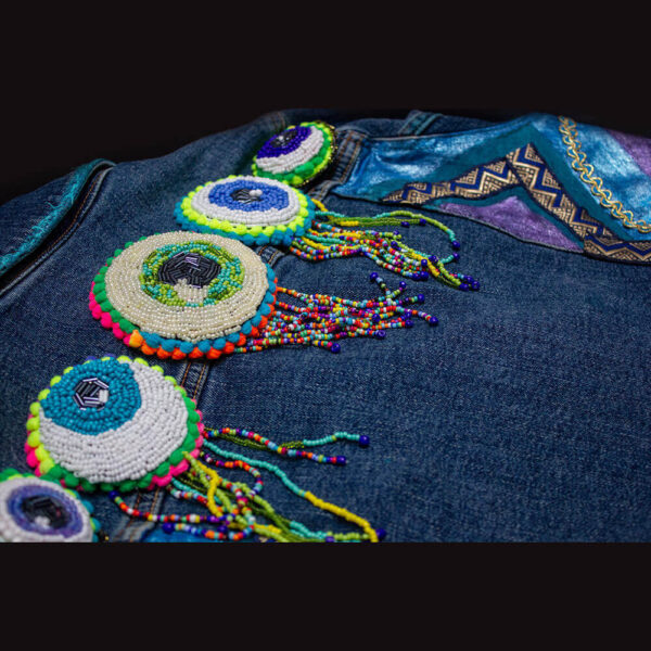 Detail of the five beaded eye patches on the back collar of the "I See You Jacket."