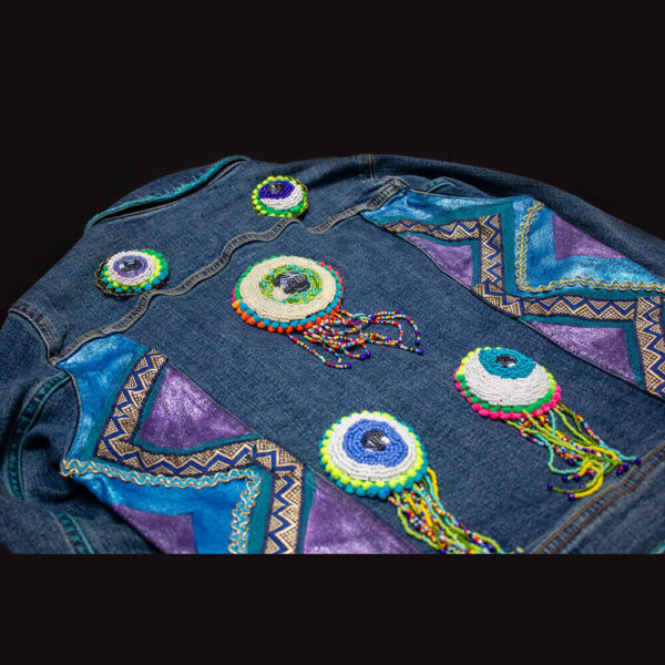 Back view of the "I See You Jacket" featuring the beaded eye patches and blue and purple metallic colors on the sides of the jacket.