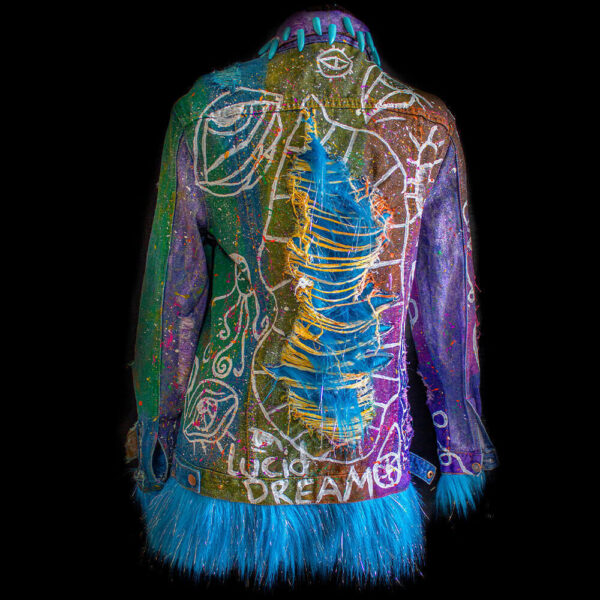 Back view of the Alien denim jacket with a ripped fabric texture, hand-painted white lines, tie-dye effects, colorful paint splatters, and added furry fabric, giving the jacket a unique and textured appearance