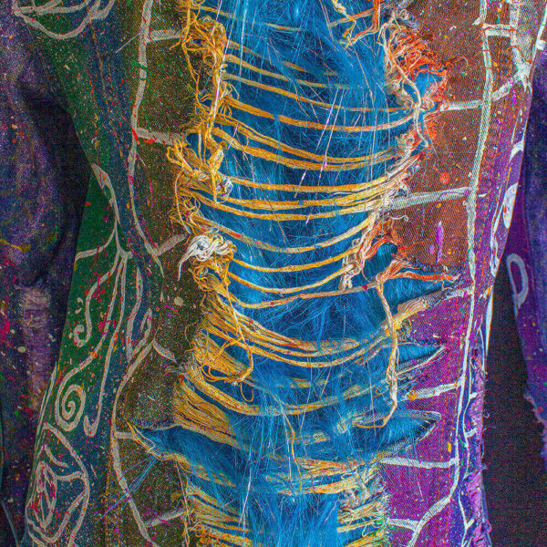 Close-up of the back view of the Alien denim jacket, highlighting the distinctive ripped effect. Below the ripped texture, you can see the added furry fabric, as well as the vibrant tie-dye process and various colored splatters on the jacket. This combination creates a visually striking and textured look