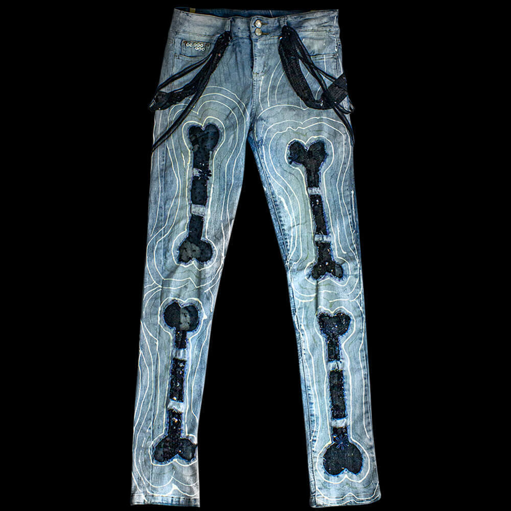 Front View of the Black Bones Denim Pants, adorned with white hand-made lines and bone designs made from black sequins lace