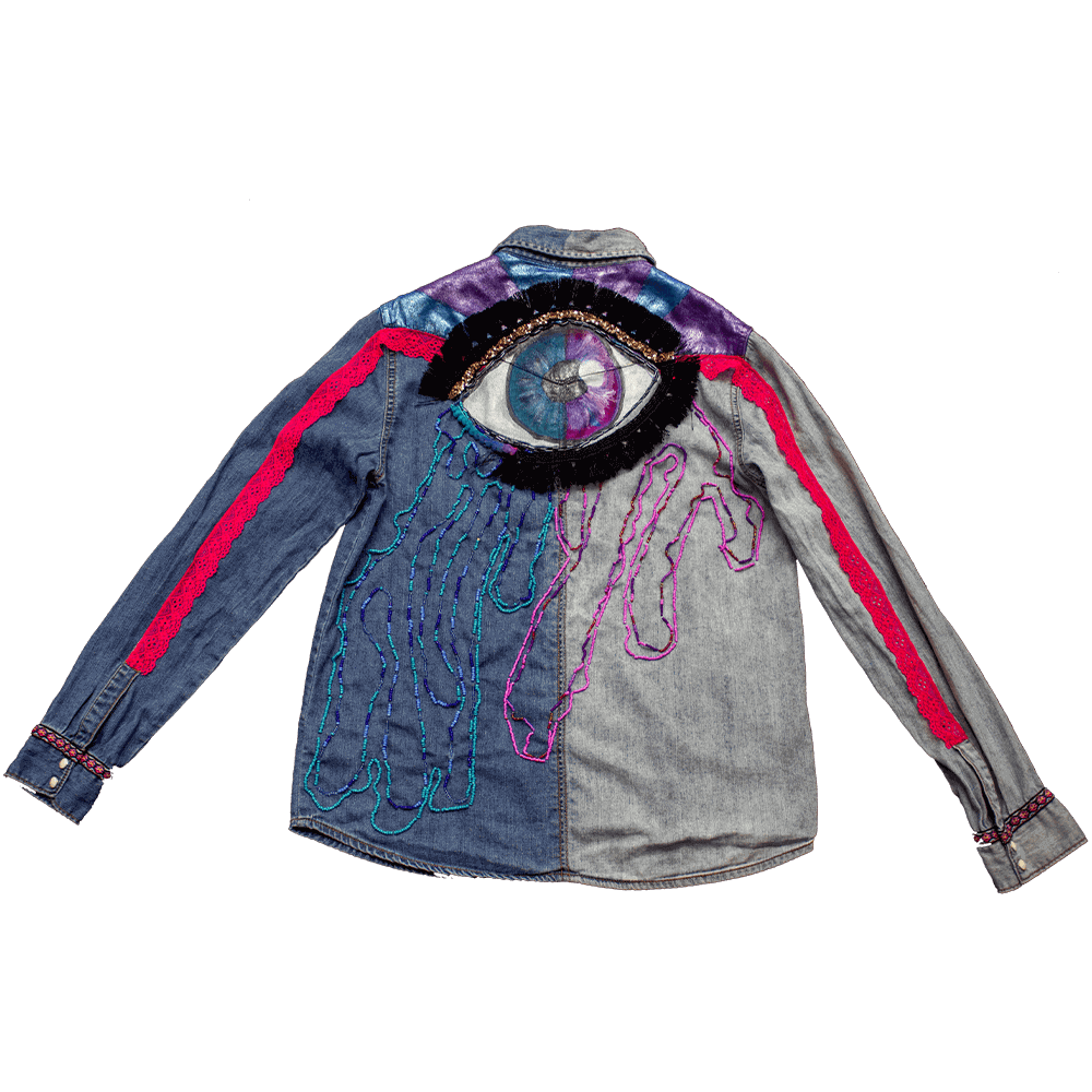 Back view of the Eye Cry Denim Blouse a garment decorated with purple and blue fabric paint details below the collar details, featuring a captivating eye adorned with golden sequins and vibrant bead tears shape accents