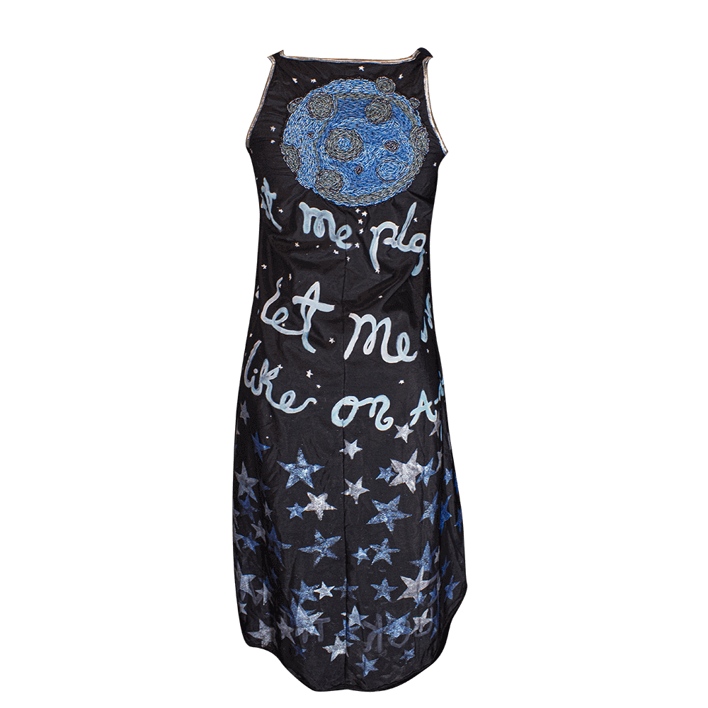 Back view of the Fly me to the Moon polyester black dress with an embroidered moon on the upper back and decorated with fabric paint all over the drees with texts and stars