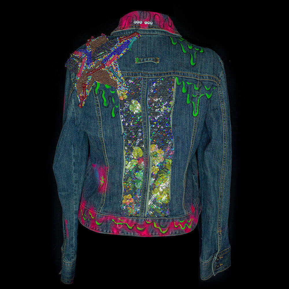 Back view of the Lau Custom Denim Upcycle Jacket, featuring decorative rainbow sequins, bold green and neon pink paint melting texture, a embroidered giant star on the left shoulder and some embroidered letters bead on the collar