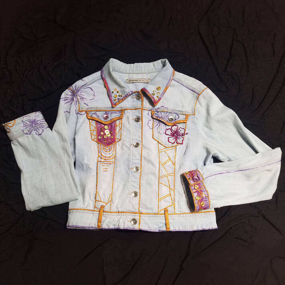 Front view of the Lau Graciano upcycled denim jacket decorated with golden and metallic purple painted textures on the collar, cuffs and front, embroidered details on collar tips and front pockets