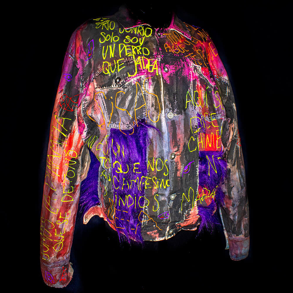 Front view of the Medallo denim jacket decorated with purple furry fabric, upcycled red fabric, fabric paint, tie dye colorized and 3D paint