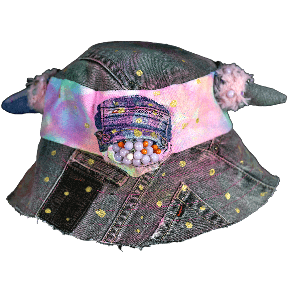 Front view of the MXD Pink bucket hat made from upcycled denim scrap, spray paint texture, golden paint dots, with furry accents on the denim horns and a Cyclop beaded eye