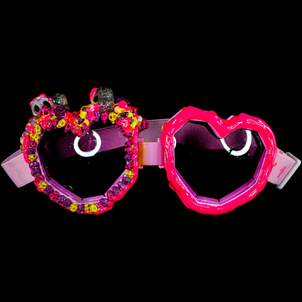 General front view of the Pink Heart Goggles decorated with 3D paint - fuchsia and yellow neon melting patterns and neon skull bead decorations, resin bones and skulls accessories