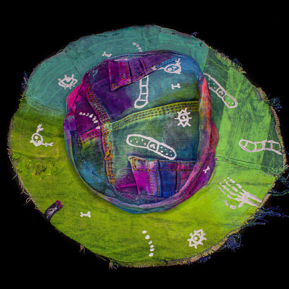 Top view of the Fuchsia Rainbow denim upcycled bucket hat, crafted from denim scraps, tie-dye textures and Dua Tua-inspired white doodles patterns