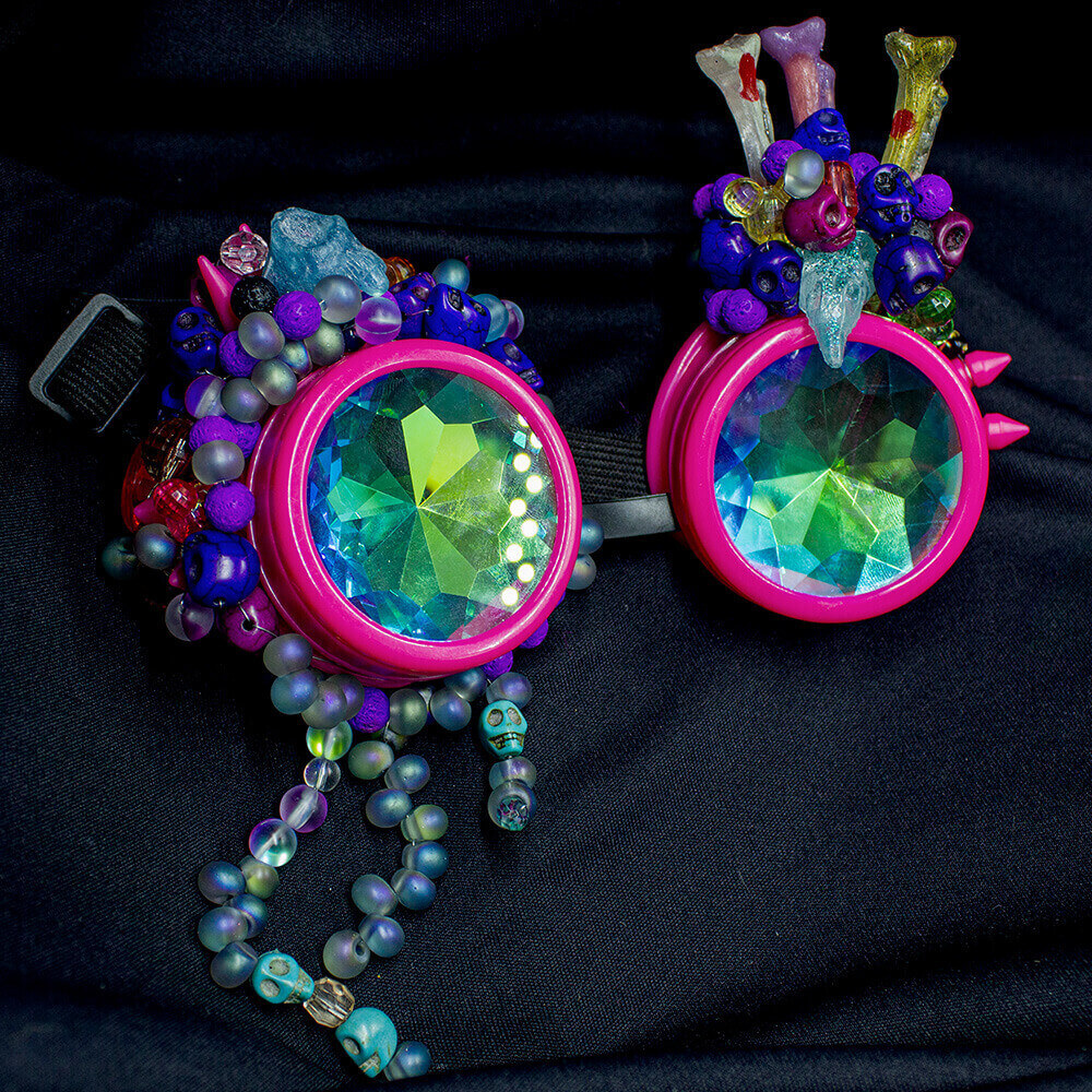 Front view of the Fuchsia Tears Goggles, circle shape lenses adorned with detailed beaded tears and resin bone accents and resin animal skulls both sides, crafted with beads embroidery and wire