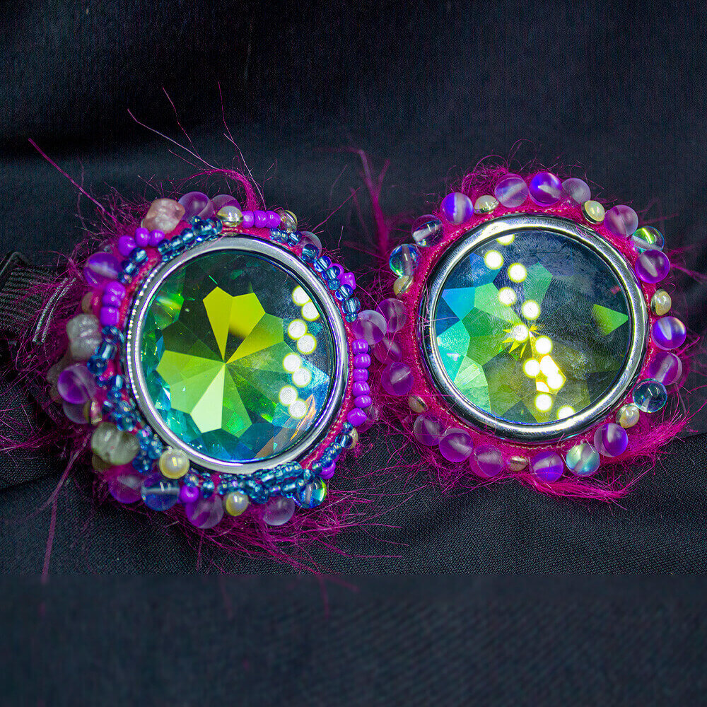 Front view of the GPink faux fur Goggles. These fuchsia goggles are adorned with furry accents, resin bones, and dazzling glass-effect beads and letter beads