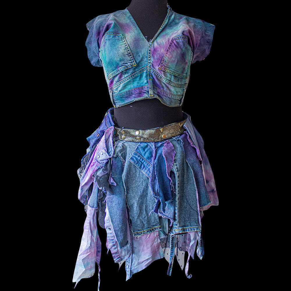 Front view of the upcycled denim blouse and skirt made from recycled denim scraps and painted with purple and blue color with a tie-dye process, right side pocket with a zipper secure detail