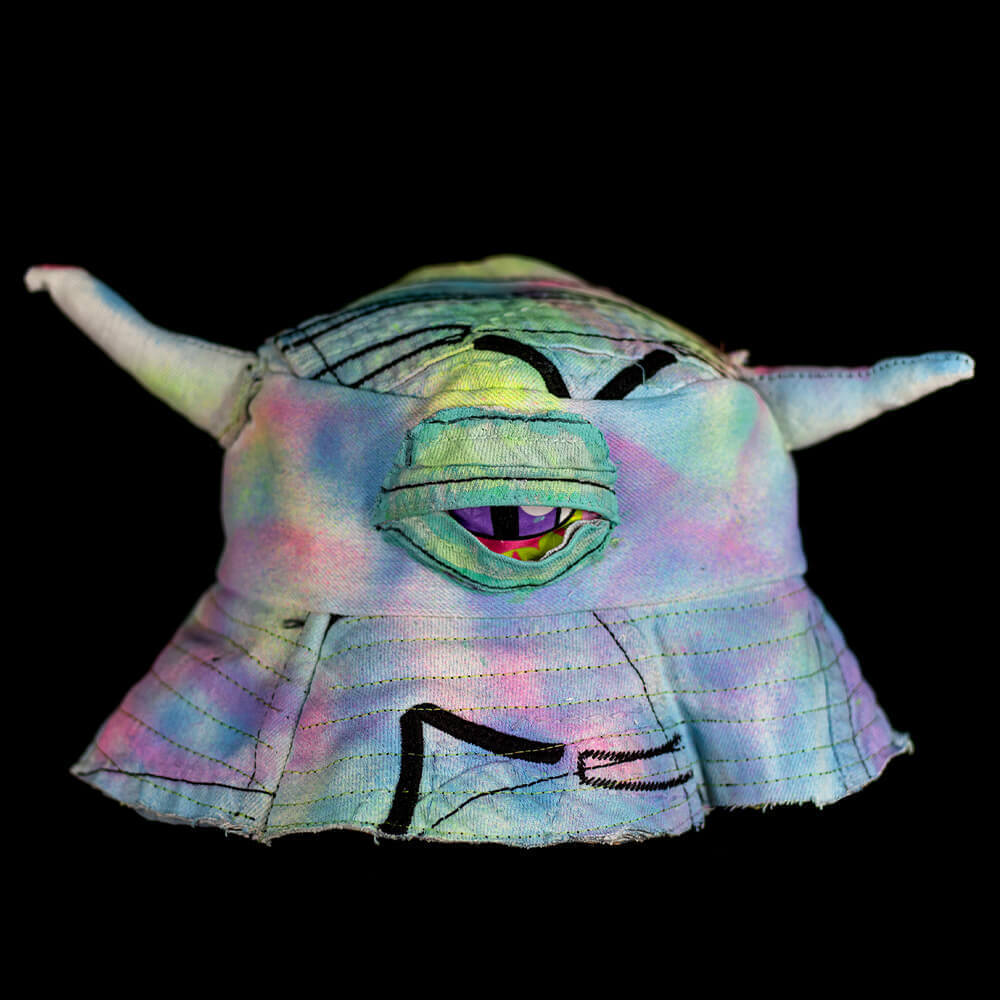 General front view of the Purple denim scraps bucket hat decorated with tie-dye hand painted texture, two horns and a single denim-eye detail up in the front middle